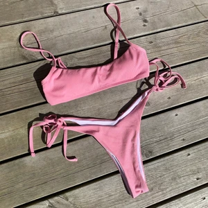 Rosa bikini - Säljer denna supersnygga bikini som aldrig är använd, skyddsplasten finns kvar! Överdelen har justerbara band och underdelen går att knyta till önskad storlek. (den andra och tredje bilden är lånad) Säljer fler bikinis på min profil🥰😊