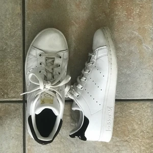 Adidas Stan Smith skor - Ett par vita Adidas Stan Smith skor med svart där bak. Storlek 36 och endast använda ett par fåtal gånger.