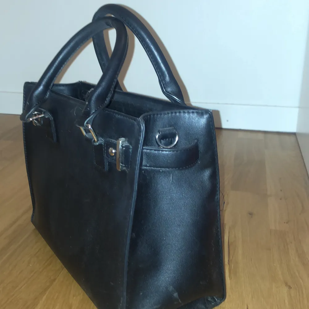 Fin svart väska i bra kvalite, knappt använd, litet fack på baksidan av väskan och tre fack på insidan av väskan.  Köparen står för frakten. Väskor.