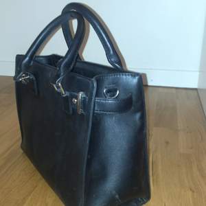 Fin svart väska i bra kvalite, knappt använd, litet fack på baksidan av väskan och tre fack på insidan av väskan.  Köparen står för frakten