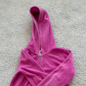 Juicy Couture tröja  - En sjuktsnygg Juicy Couture tröja. Den är rosa och coola detaljer på baksidan. Koftan har en dragkedja som fungerar och har en luva. Tecken på användning finns men lätt att fixa.Står att de är storlek L men skulle säga att den är en XS. Tröjan är croped.                                       ❗️KÖPAREN STÅR FÖR FRAKT❗️