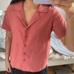 kortärmad blus skjorta strl M - Färg: ljus vattenmelon röd. M: Total längd: 59 cm, Axelbredd : 36 cm, Byst: 92 cm, fåll: 66 cm, ärmlängd: 21,5 cm, manschett: 27,5 cm. Köpt från koreanska hemsidan Yesstyle