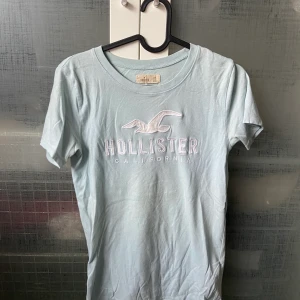 Babyblå T-shirt från Hollister - Säljer min SÅSÅSÅ sköna T-shirt från Hollister!💙 Den är knappt använd och sitter superfint❗️Älskar den ljusblåa färgen men den kommer inte till användning... Köpare står för frakt 