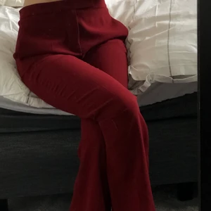 Vinröd kostymbyxa - Vinröda kostymbyxor i en utsvängd modell. Lågmidjadd, storlek xs. Dom är uppsydda men är bra längd på mig som är 163cm.