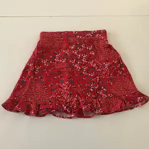 Fin röd blommig kjol med volanger och knappdetaljer. Stretchig i midjan, så passar både XS och S. Vet ej vilken butik den kommer från då den är köpt utomlands. Köparen står för frakten 💗