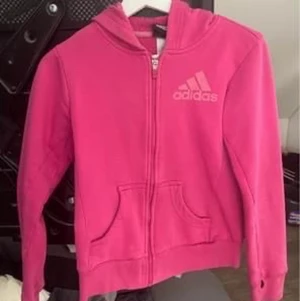Adidas hoodie  - Rosa adidas tröja med luva i fint skick i storlek 10/12år. Passar även xs. Sparsamt använd och inte synda hål eller sömmar som gått upp.   Finns i Göteborg