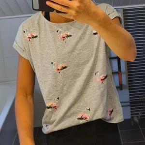 Grå T-shirt med flamingos - Säljer en ljusgrå t-shirt från etc med rosa paljettflamingos i storlek S 😊