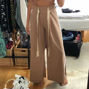 Festbyxor - Jättecoola och snygga byxor i beige och vitt. Aldrig andvända i perfekt skick. De är väldigt sköna och passar S,M och L eftersom det är stretchiga i midjan. 🤗 priset kan förhandlas vid intresse.