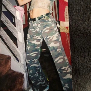 CARGO BYXOR CAMOUFLAGE - Vintage Y2K Cargo Byxor i kamouflage. De är lite utsvängda vid benen vilket gör att de sitter så fint över skor. Super snygga och passar S. Kan även passa XS beroende på hur man vill att de ska stta. Första bilden är från förra ägaren.