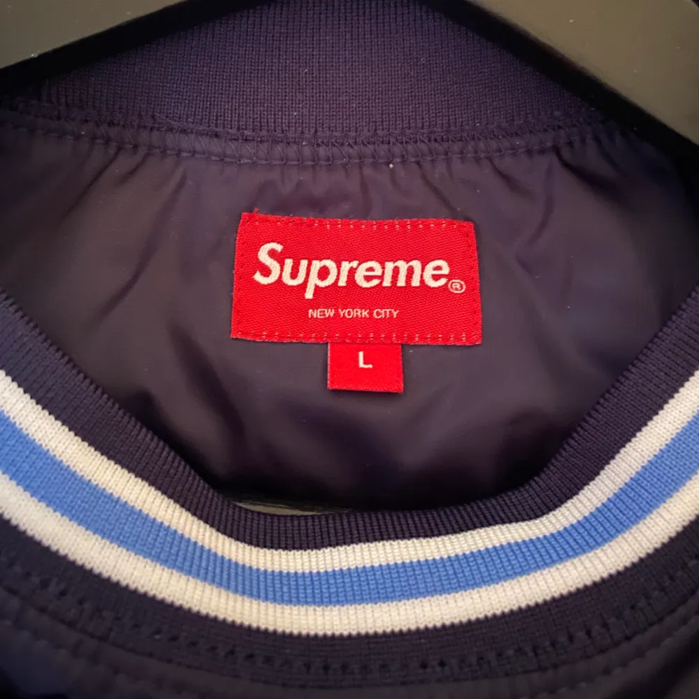 Äkta tröja från Supreme Nyc. ”Vindjacksmaterial” på utsidan och i kragen, annars är insidan täckt av en mjuk, ljusgrå bomull. Mycket snygg å nice tröja som jag bara har använt en gång!   Lite svårt att få till en bra bild då det mörkblåa materialet reflekterar flashen, men skriv om ni vill se mer! ⚡️🙏🏻. Hoodies.