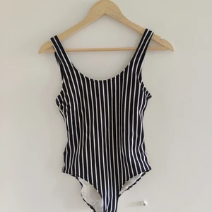 Ribbad baddräkt strl 36 - Fin ribbad baddräkt i väldigt mörkblå och vit färg som tyvärr bara hänger i garderoben. Har några år på nacken men har använt den som max 4 gånger. Hittar inga anmärkningar. 