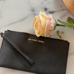 Michael Kors Kuvertväska - Kuvertväska från Michael Kors, väldigt sparsamt använt. Man får plats med kort, lite läppglans och självklart det viktigaste MOBILEN!!!! OBS äkta!!