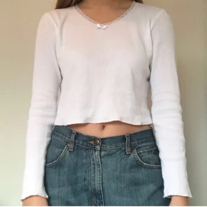 Brandy Melville-tröja med spetsdetalj - En supersöt vit tröja från Brandy Melville med rosett och spetsdetaljer. Köptes här på Plick men kände inte att den passade min stil så säljer den vidare :)