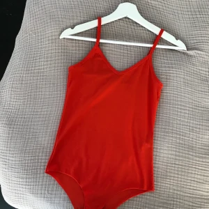 Body  - Röd skitsnygg body i fint skick :) Köparen betalar frakten 