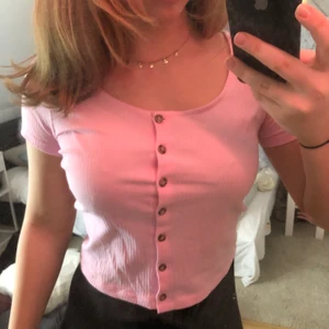 Rosa t-shirt med knappar från monki - Säljer denne rosa t-shirt med knappt från monki i storlek S, den är ”Ribbad”.Använd en gång.😋 