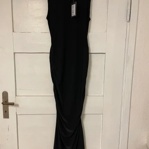 SVART KLÄNNING STL L - Svart ”ruched” klänning i storlek L. Aldrig använd med prislappen kvar. Budgivning startar på 100 kr i komentarsfältet, köp direkt för 150 