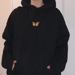 Brandy Melville butterfly hoodie - Svart oversize hoodie från Brandy Melville. Den har en gul/orange fjäril i mitten. Storleken är onesize och skulle passa mellan xs (oversize) till L/XL (normal passform). Använd en gång.