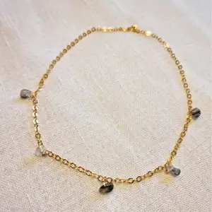 Guldfärgat halsband med små kristaller av turmalin I kvarts 💎 Kedjan är ca 40 cm lång, och passformen går att justera. Skickas i vadderat kuvert via postnord. 