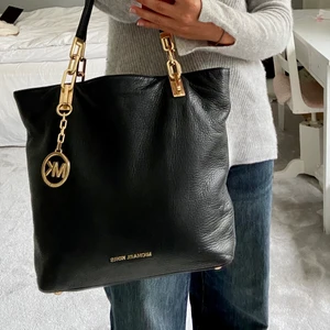 Michael Kors väska  - Svart Michael Kors väska med guld detaljer. Är i väl godkänt skick, inga synliga anmärkningar på lädret eller gulddetaljerna. Väskan har blivit väl omhändertagen för att behålla den goda kvaliten på lädret. Super fin och klassisk väska. Har även många bra innerfack! 