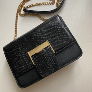 Väska från NAKD - Väska i gottskick i skinnimitation. 