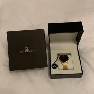 En helt ny Original 40 Cote D'Azur Waldor & CO klocka i färgen gold. Klockan är oanvänd och har fortfarande sin förpackning kvar.  Klockan är köpt för 2000kr