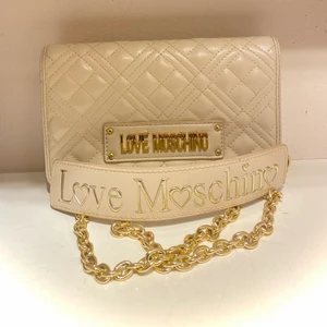Love Moschino väska  - Andvänd ett fåtal gånger, jättefin beige väska med guldiga detaljer. Köpt för 1200