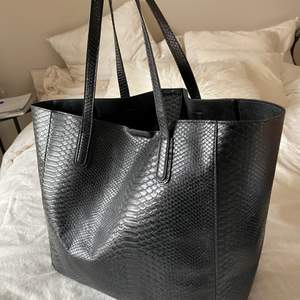 Stor svart väska från NELLY   Läderimitation  Kan förslutas med knapp på insidan  Mått: Bredd 37,5 cm, Höjd 34 cm, Djup 20 cm 