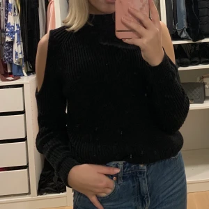 Stickad tröja  - Svart stickad tröja med hål vid axlarna. Använd ett fåtal gånger så den e i bra skick