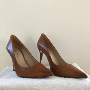 Pumps (massimodutti)  - Fina kamelfärgade pumps i äkta läder. Storlek 37 med en klack på 9,5 cm. Använda ett fåtal gånger inomhus. Från märket MassimoDutti. Köpta för 900kr.