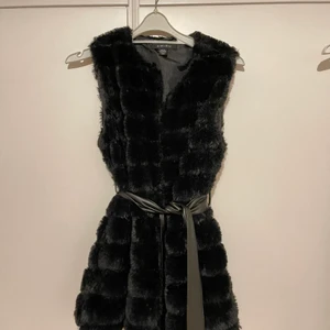Svart pälsväst i storlek 36 - Svart pälsväst i storlek 36. Den har använts några gånger, men ser ut som ny och känns som ny💗 Den kommer med ett band som gör att det kan sitta mer tight och ger en mer form. Den har också fickor!!