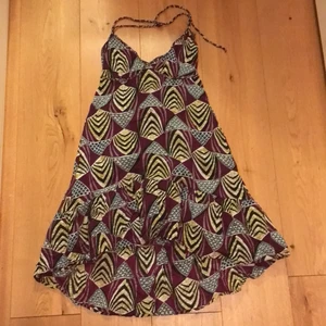 Mönstrad klänning strl S - En somrig mönstrad klänning i mörklila från Indiska. Ser ny ut och är gjord av ett skönt material. Storlek S. Frakt ej inkluderat 