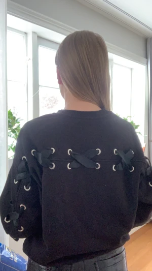 Sweatshirt med snörning  - Snygg svart sweatshirt med snörning längs rygg och armar