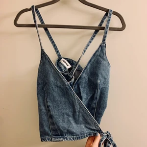 Linne weekday - Ett omlottlinne i jeans från weekday i st.S. Använd bara en gång i somras, modellen är cropped och skitsnygg till både byxor och kjol🩰🌺