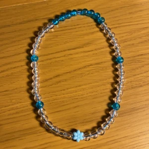 Halsband - Ett egengjort halsband med små detaljer. Även en blomma i mitten som du ser på andra bilden. Sitter ganska tajt på mig, kanske 3 cm hängande typ utanför halsen, men det beror ju på hur din hals ser ut. Frakt kommer vi överens om hur vi gör sen.
