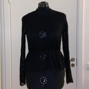 Svart Spetstopp - Genomskinlig svart spetstopp med volang och liten krage