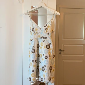 Kort blommig klänning från LMC - Kort blommig klänning med snörning där bak från LMC. Bra skick. Frakt tillkommer.
