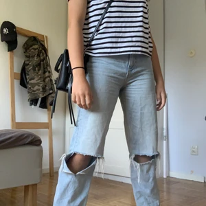 Jeans med hål  - Jättefina högmidjade jeans från ginatricot med hål på knäna. De är mycket använda men fortfarande i bra skick. De är i storlek 32. Köptes för 599 kr. Du står för frakten😊💗