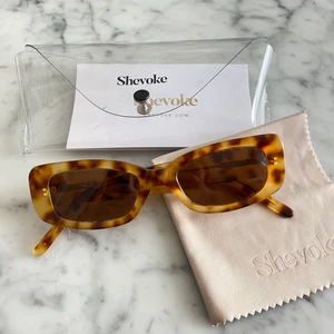 Shevoke solglasögon - Smala 90s inspirerade solglasögon från det Australiska märket Shevoke. I använt men bra skick! Kostade 129 AUD vilket motsvarar ca 850kr. Säljes för 250kr. Fodral och mikrofiberduk medföljer. Sista bilden är lånad.