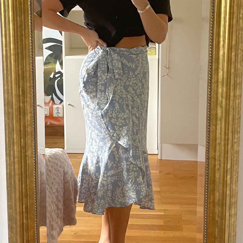 Härlig, vit- och blåblommig kjol som jag köpte på Gina Tricot i juni 2021!!💙 Fin volang och knyte i midjan så den passar mindre och större storlekar!! Säljer pga att den inte kommit till användning mer än 1 gång🤍😇 Nypris: 449. Kjolar.