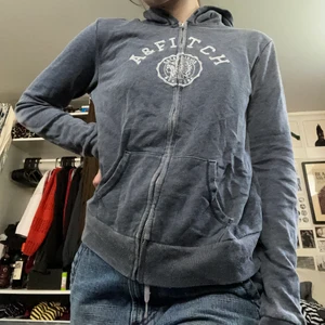 Hoodie - Gråblå hoodie från abercrombie & fitch. Tyvärr sakna snören. Väldigt mjuk. Det står storlek M men skulle snarare säga S