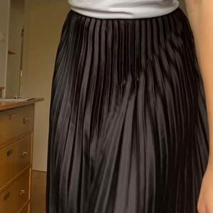 En plisserad kjol som går nedanför knäna. Köpte på Plick men har aldrig använt den. I väldigt bra skick. 