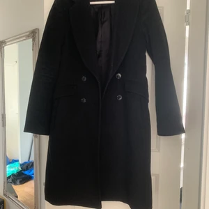 Svart kappa - Svart figursydd kappa i storlek 32/XS. Sparsamt använd och riktigt fint skick! Kan mötas eller skickas med Postnord skicka lätt.