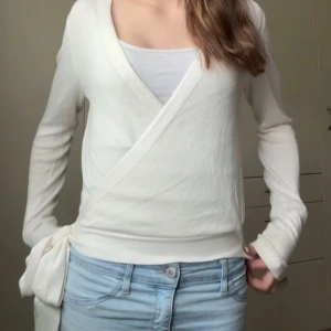 Vit omlottopp från Pieces - Jätte fin stickad tröja från Pieces med knytning 💓 Den är i fint skick men har en liten fläck på framsidan (se sista bilden) Pris går att diskutera! Hör gärna av dig vid frågor eller för info 🩷