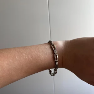 Silverfärgat armband med kedjelänkar - Säljer ett stilrent armband i silverfärg med rejäla kedjelänkar. Perfekt accessoar för att lyfta din outfit med en modern touch. Passar både till vardag och när du vill känna dig extra snygg.