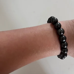 Svart pärlarmband - Snyggt svart armband med runda pärlor. Elastiskt band gör det enkelt att ta på och av. Passar perfekt för dig som gillar stilrena accessoarer med en cool vibe.