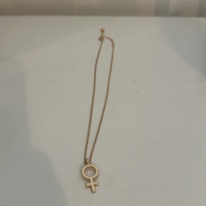 Guldigt halsband med kvinnosymbol - Snyggt halsband i guld med ett hänge i form av kvinnosymbole, använd Max 2 gånger🥰