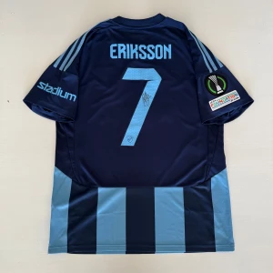 Djurgårdens IF matchtröja Eriksson 7 använd och autograf  - Nu har du som Djurgårdsfan eller samlare chans att buda hem denna otroligt mäktiga fotbollströja signerad och matchanvänd av ingen annan än Djurgårdens före detta lagkapten Magnus Eriksson.   Denna matchtröja använde Magnus Eriksson när Djurgården 2024/08/15 mötte ilves hemma i Europa Conference League (ECL) där dem starkt vann!   Han har efter 7 säsonger med Djurgården nu tackat för sig!   Totalt har det blivit 208 tävlingsmatcher med 32 mål och 44 assist i den blårandiga tröjan för Mange