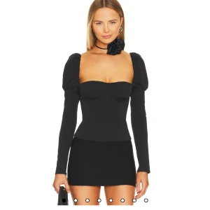 Svart långärmad festtopp - Supersnygg svart festtopp med figurnära passform och  korsettliknande💗💕 Köpt på revolve för ca 1350kr, aldrig använd!