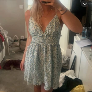 Blommig sommarklänning med öppen rygg - Så fin kortklänning med blommor! Fint skick! Banden är sånna som man kan knyta upp sjölv vid axlarna och bestämma hur man vill ha dem💕