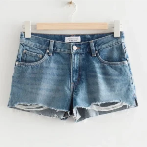 Blå jeansshorts från Other Stories - Säljer ett par supersnygga lågmidjade shorts från Other Stories. Är i storlek 32.  Perfekta för sommaren och enkla att matcha med allt.